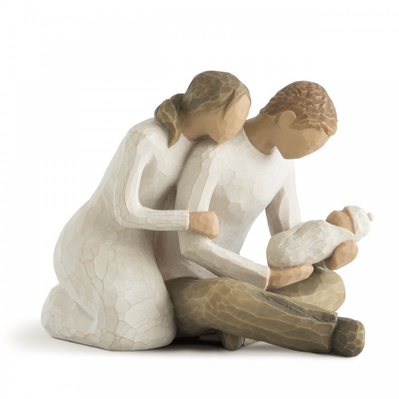 Man and woman figurines holding baby