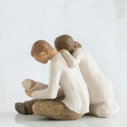 Man and woman figurines holding baby