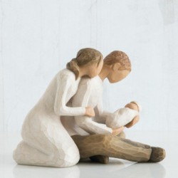 Man and woman figurines holding baby