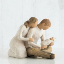Man and woman figurines holding baby
