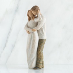 Man hugging woman figurine