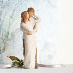 Man hugging woman figurine
