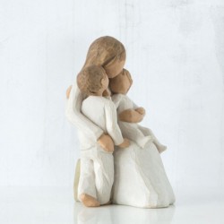 Mother figurine with arms wrapped around two children