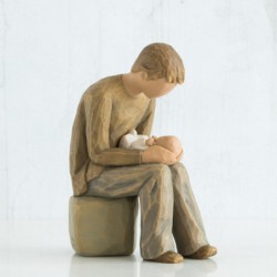 Boy sitting on rock holding a baby figurine