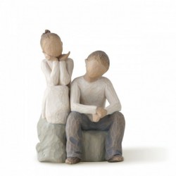 Little girl and boy figurines sitting on rocks