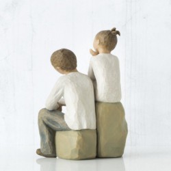 Little girl and boy figurines sitting on rocks