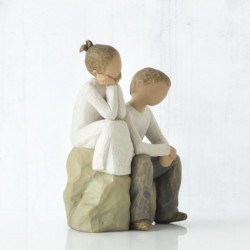 Little girl and boy figurines sitting on rocks