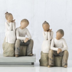 Little girl and boy figurines sitting on rocks