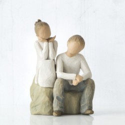 Little girl and boy figurines sitting on rocks