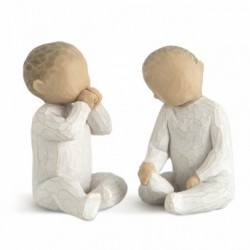 Two small baby figurines in all white onesies sitting down