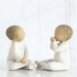 Two small baby figurines in all white onesies sitting down