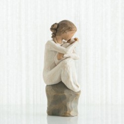 Faceless girl sitting on grey rock with arms holding baby