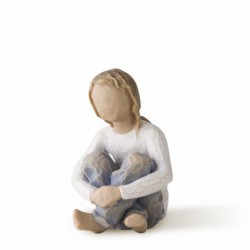 Small faceless figurine girl wearing white shirt and blue jeans with hands crossed on her legs