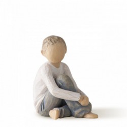Faceless little boy sitting down wearing white shirt and jeans with hands over legs