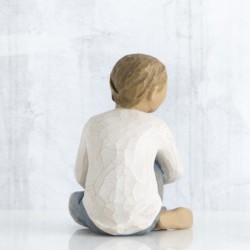 Faceless little boy sitting down wearing white shirt and jeans with hands over legs