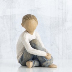 Faceless little boy sitting down wearing white shirt and jeans with hands over legs