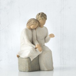 Faceless man and woman figurines sitting on rock wearing all white