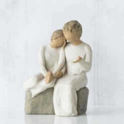 Faceless man and woman figurines sitting on rock wearing all white