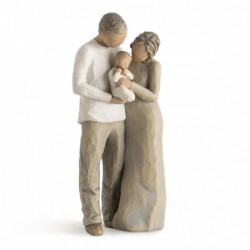 Mother and father figurines standing holding baby wrapped in white onesie