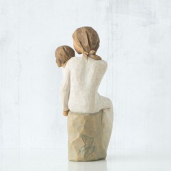 Woman figurine in white dress holding younger girl in her arms