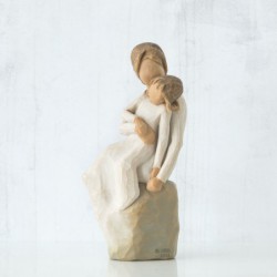 Woman figurine in white dress holding younger girl in her arms