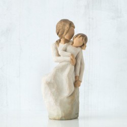 Woman figurine in white dress holding younger girl in her arms