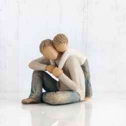 Father figurine sitting down hugging boy figurine from behind - both are wearing blue jeans and white shirts