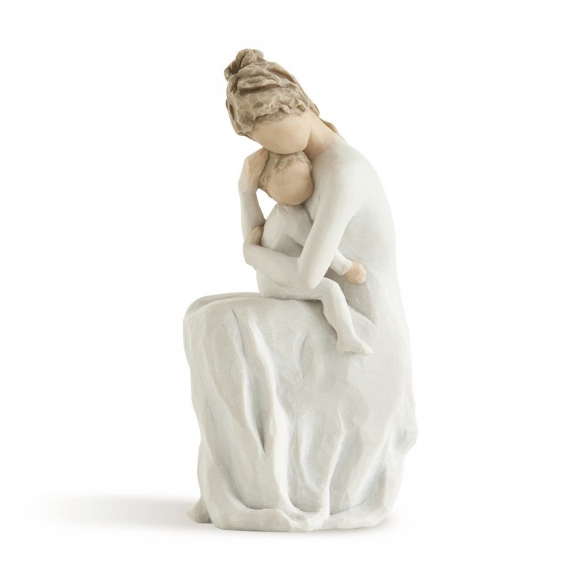 Mother figurine in white dress sitting down holding baby in her arms