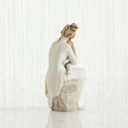 Mother figurine in white dress sitting down holding baby in her arms