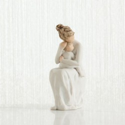 Mother figurine in white dress sitting down holding baby in her arms