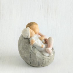 Young girl figurine sitting in light pink dress holding tiny baby in her arms - sitting on grey plush bean bag