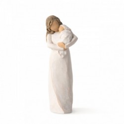 Front view of brunette woman figurine in white dress holding swaddled baby