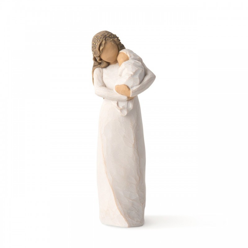 Front view of brunette woman figurine in white dress holding swaddled baby