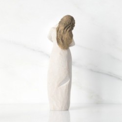 Front view of brunette woman figurine in white dress holding swaddled baby