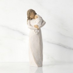 Front view of brunette woman figurine in white dress holding swaddled baby