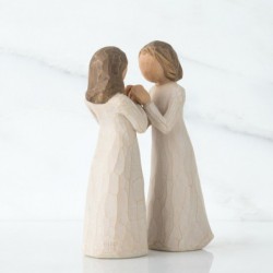 Two little girl figurines facing one another holding hands