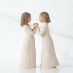 Two little girl figurines facing one another holding hands