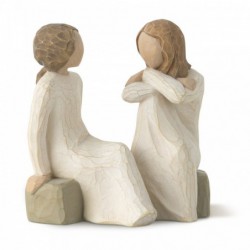 Two little girl figurines sitting on rocks looking at one another