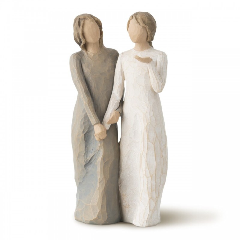 Two woman figurines standing side by side - left has brown dress on