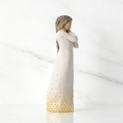 Front view of brunette girl figurine in white dress with gold dots holding her hands to her face