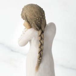 Front view of brunette girl figurine in white dress with gold dots holding her hands to her face