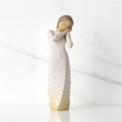 Front view of brunette girl figurine in white dress with gold dots holding her hands to her face