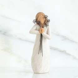 Woman figurine holding black flowers to her face