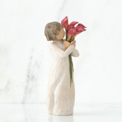 Front view of little girl with short brown hair holding a cluster of red calla lilies