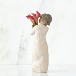 Front view of little girl with short brown hair holding a cluster of red calla lilies
