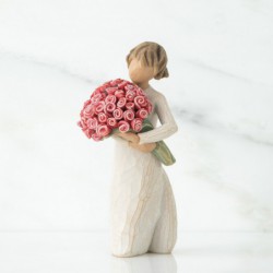 Small girl figurine in white dress holding pink flower bouqet