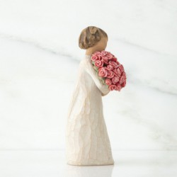 Small girl figurine in white dress holding pink flower bouqet