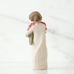 Small girl figurine in white dress holding pink flower bouqet