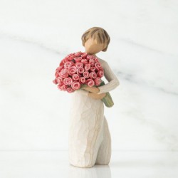 Small girl figurine in white dress holding pink flower bouqet