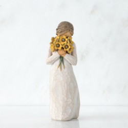 Side view of woman with tied back brown hair holding a cluster of yellow flowers to her face